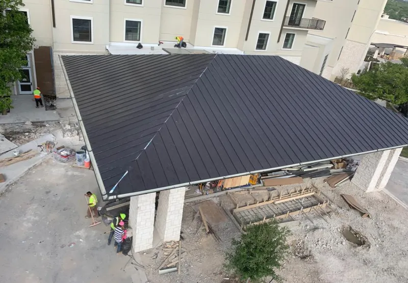 Metal roofing installation team working on a commercial building in Tulsa